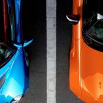 orange and blue cars in parking spaces